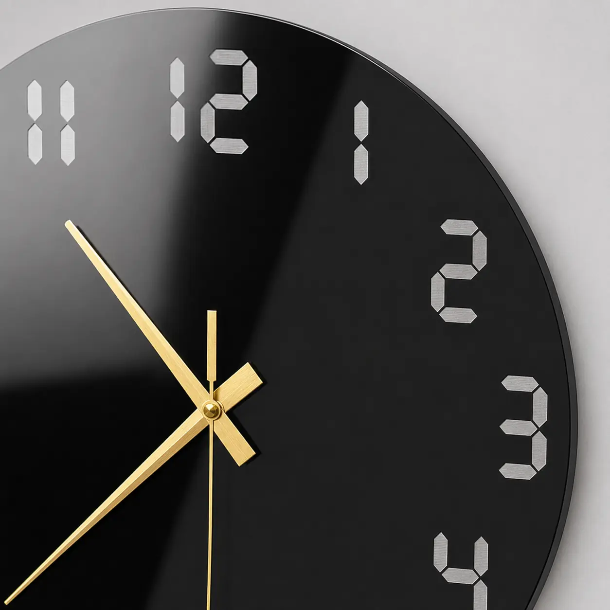 Close-up of glossy black acrylic clock with silver seven-segment numerals and metallic gold hands