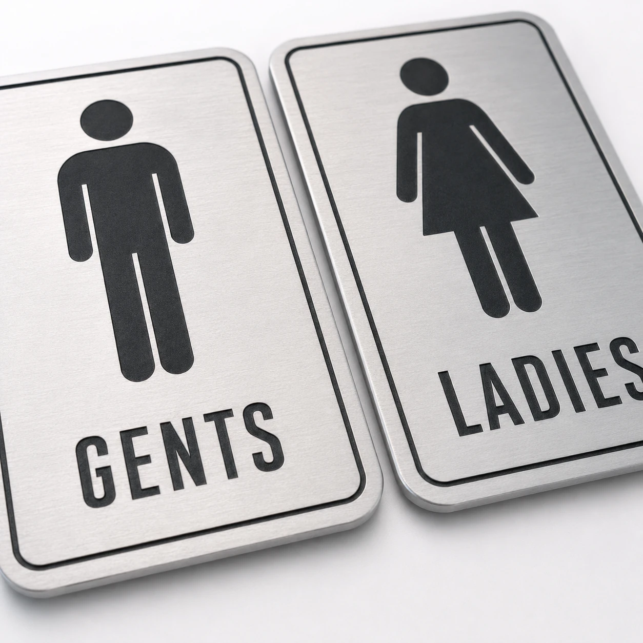 Close-up of 1.5 mm brushed silver ABS restroom signs with black engraving