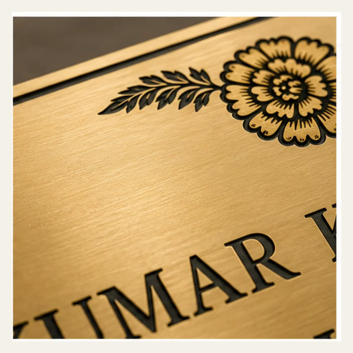 Brushed gold engraving close-up of personalised botanical marigold brushed gold abs name plate with black engraving and 3M tape mounting