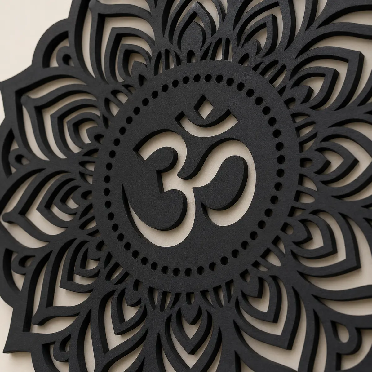 Close-up of matte black MDF Om mandala centre, texture and laser-cut edges