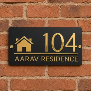 Matte black and shiny gold acrylic address plate showing 104 and Aarav Residence