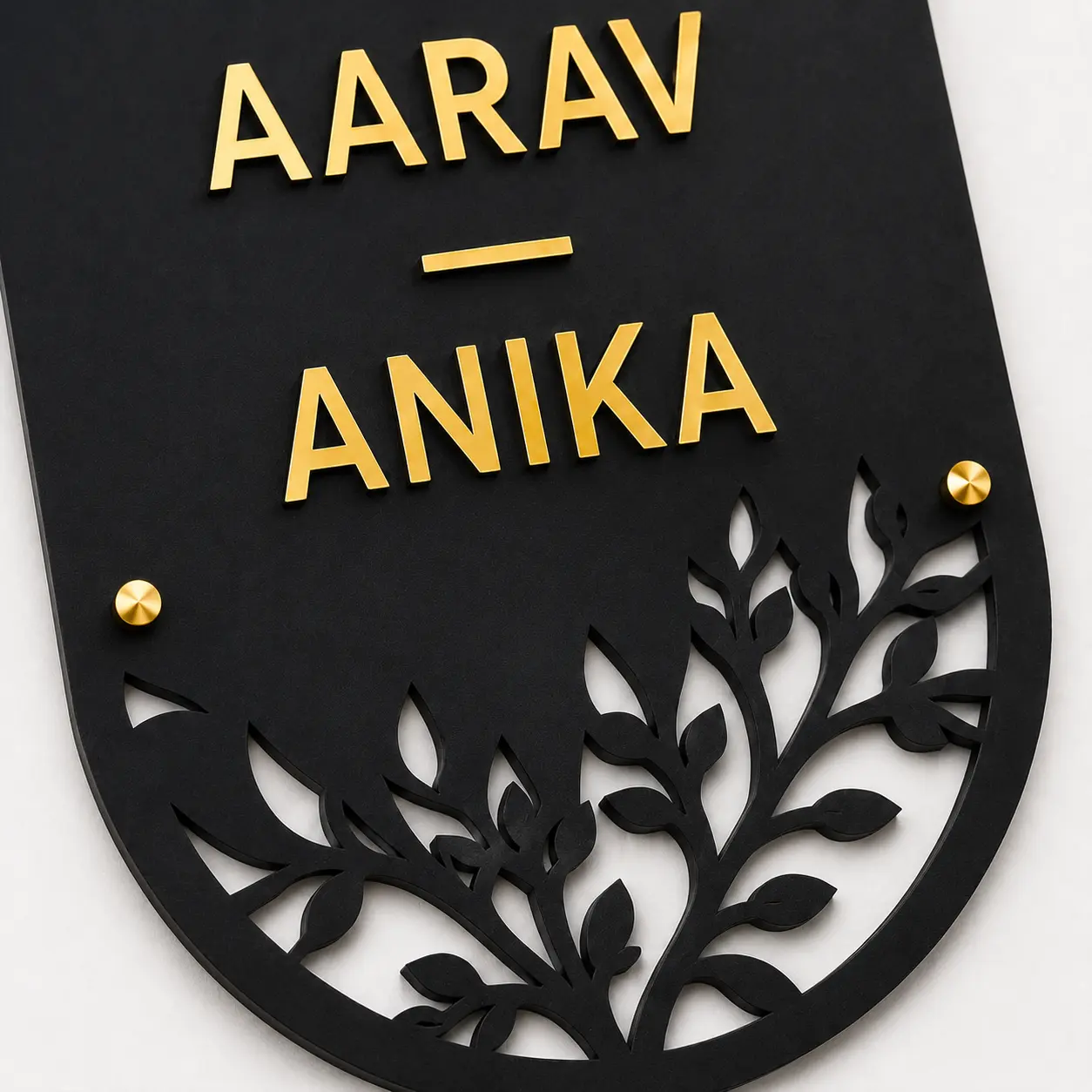 Close-up of AARAV and ANIKA gold-mirror acrylic names and botanical laser-cut detail