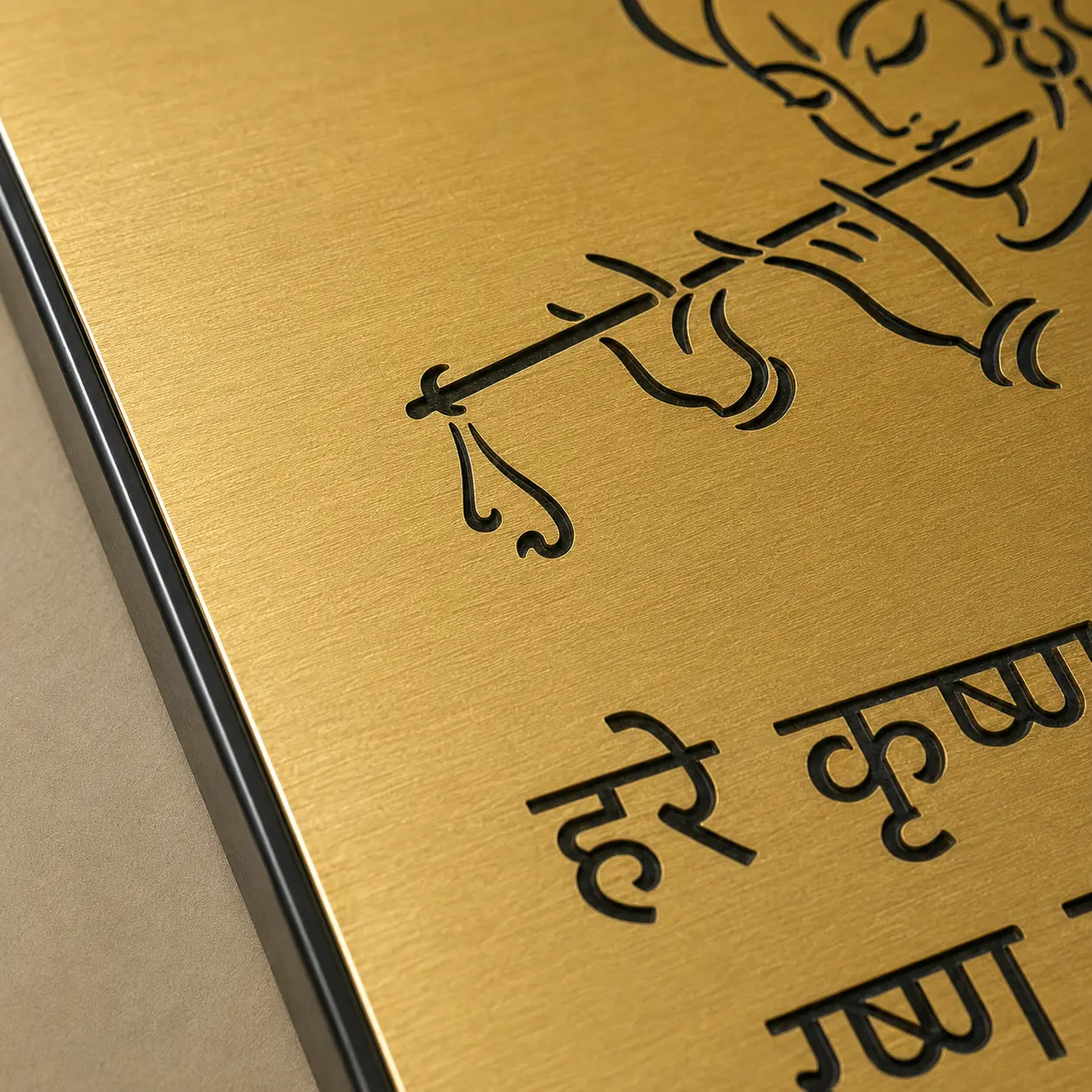 Close-up of Krishna artwork laser engraving on brushed gold