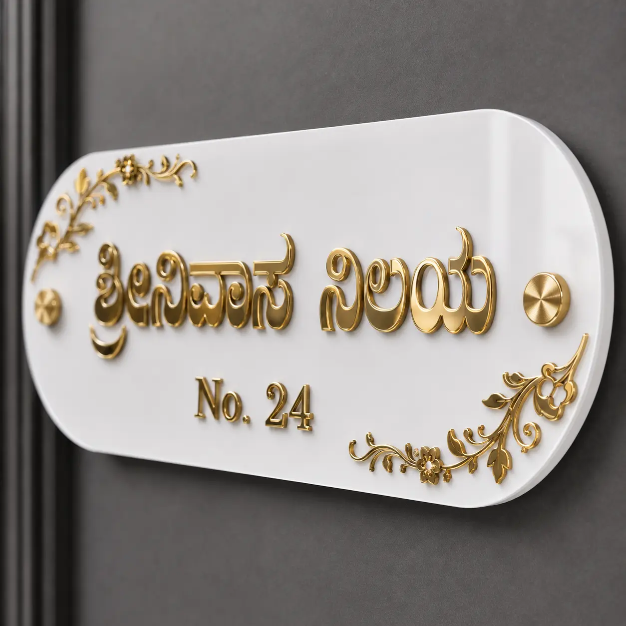 Close-up of black acrylic base, mirror-gold Kannada letters, Ganesha motif and gold stud