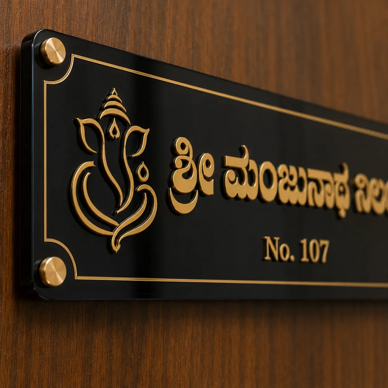 Close-up of white acrylic base, mirror-gold Kannada letters, floral detail and gold stud