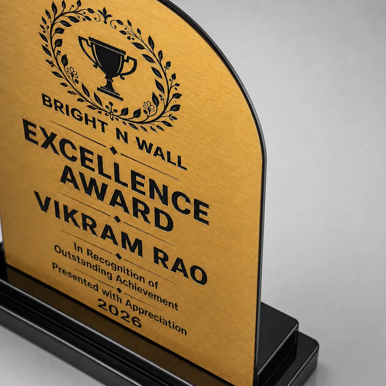 Rounded arch award trophy close-up showing 1.5 mm brushed gold face and slim 3 mm black acrylic backing